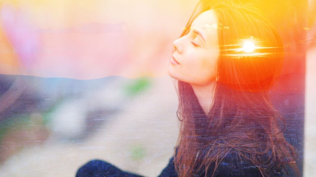 Intuitive woman with mountains and sun behind her