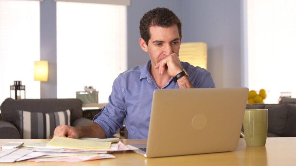 Man looking at his laptop concerned