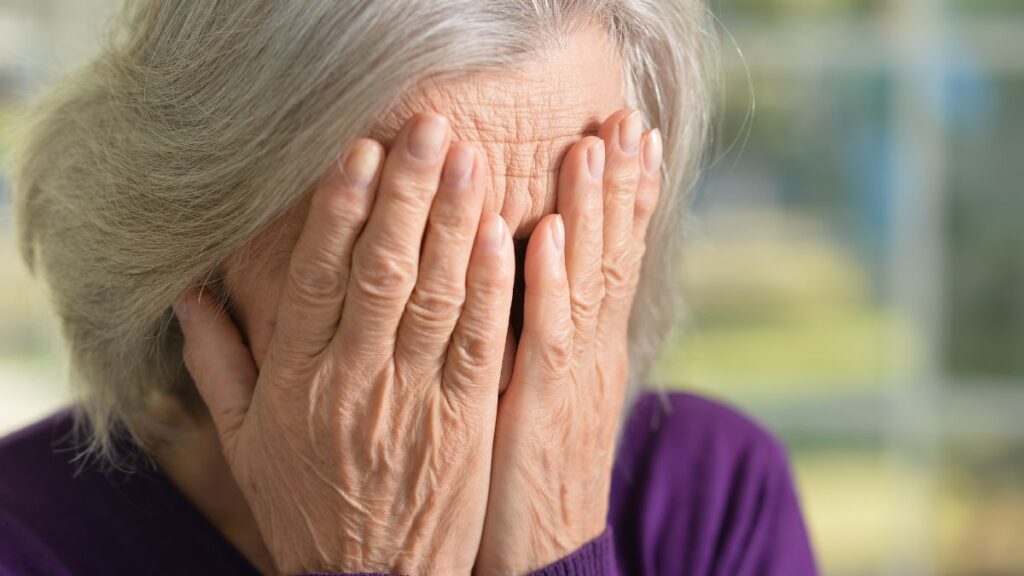 Older lady hiding her face upset