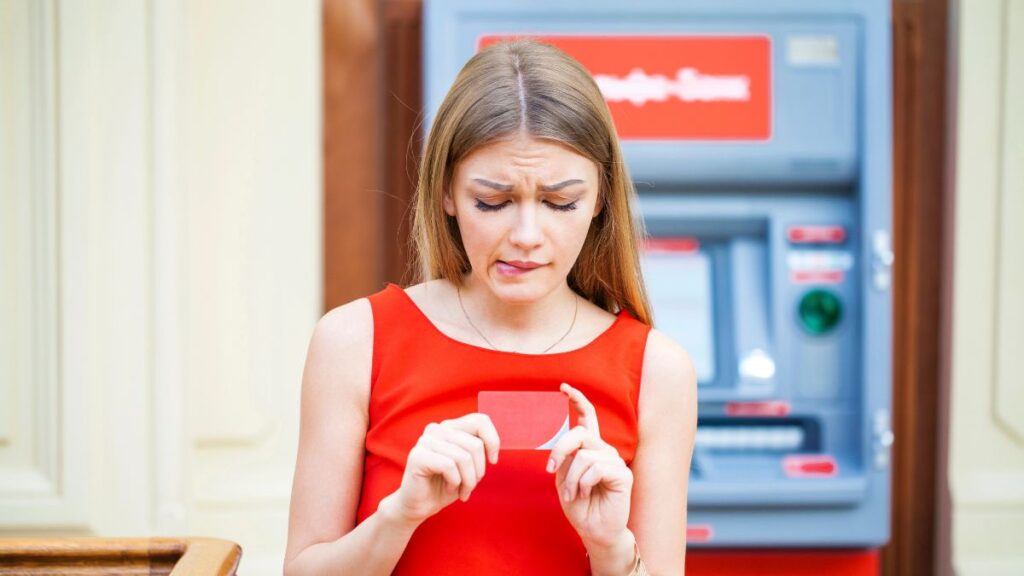 Woman looking up holding her credit card