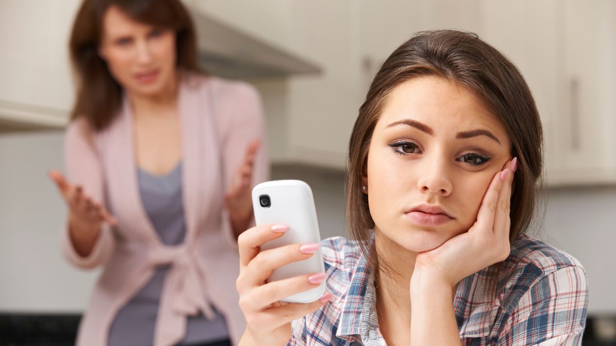 annoyed teen with irritated mom in back