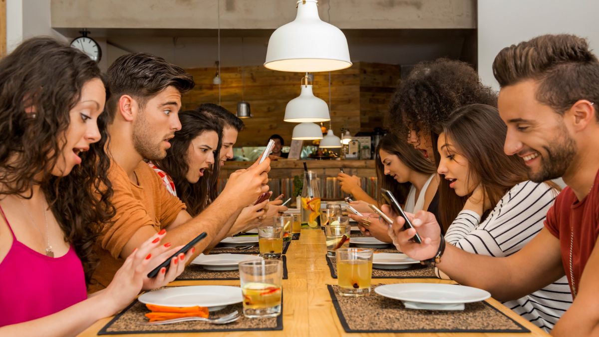 friends looking at phones at dinner