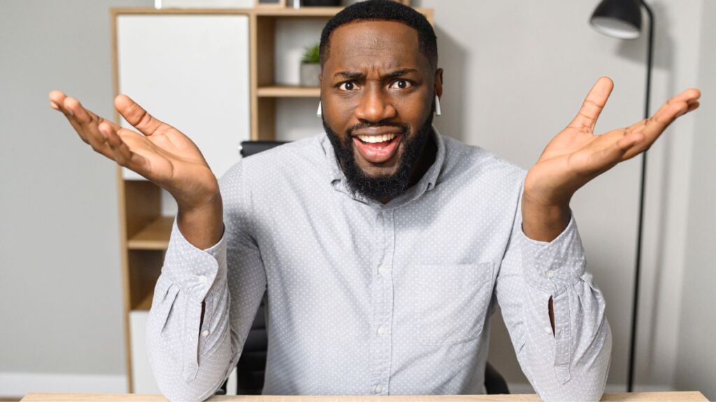 frustrated man sitting with hands up