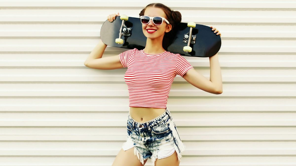 gen z woman posing with skateboard