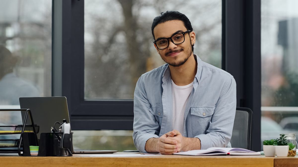 happy man sitting at desk smiling