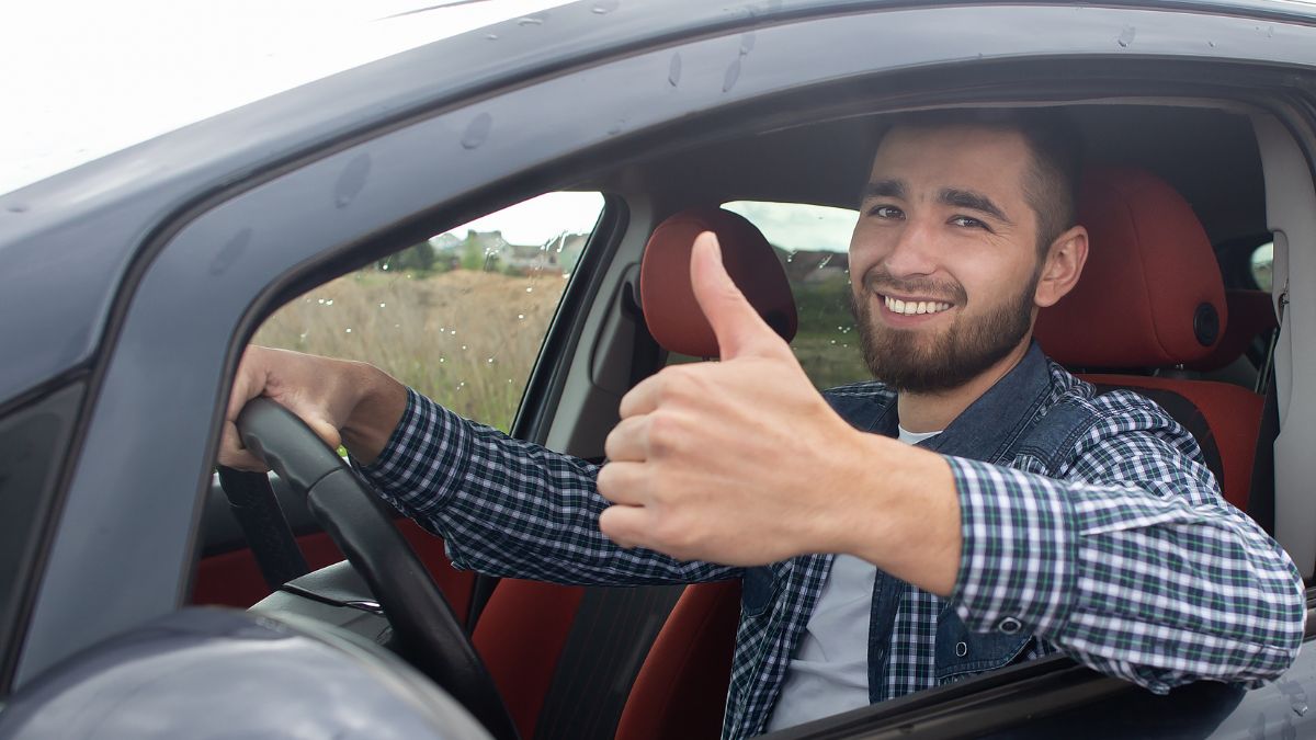 man driving with thumbs up