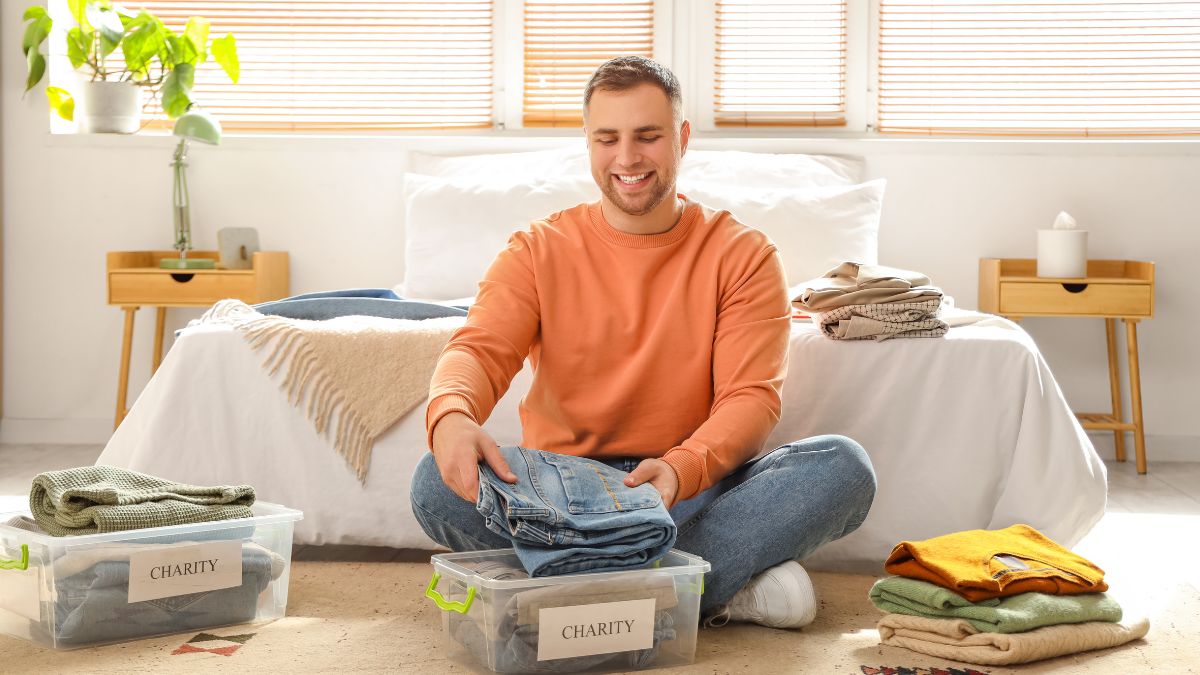 man folding clothes for donation