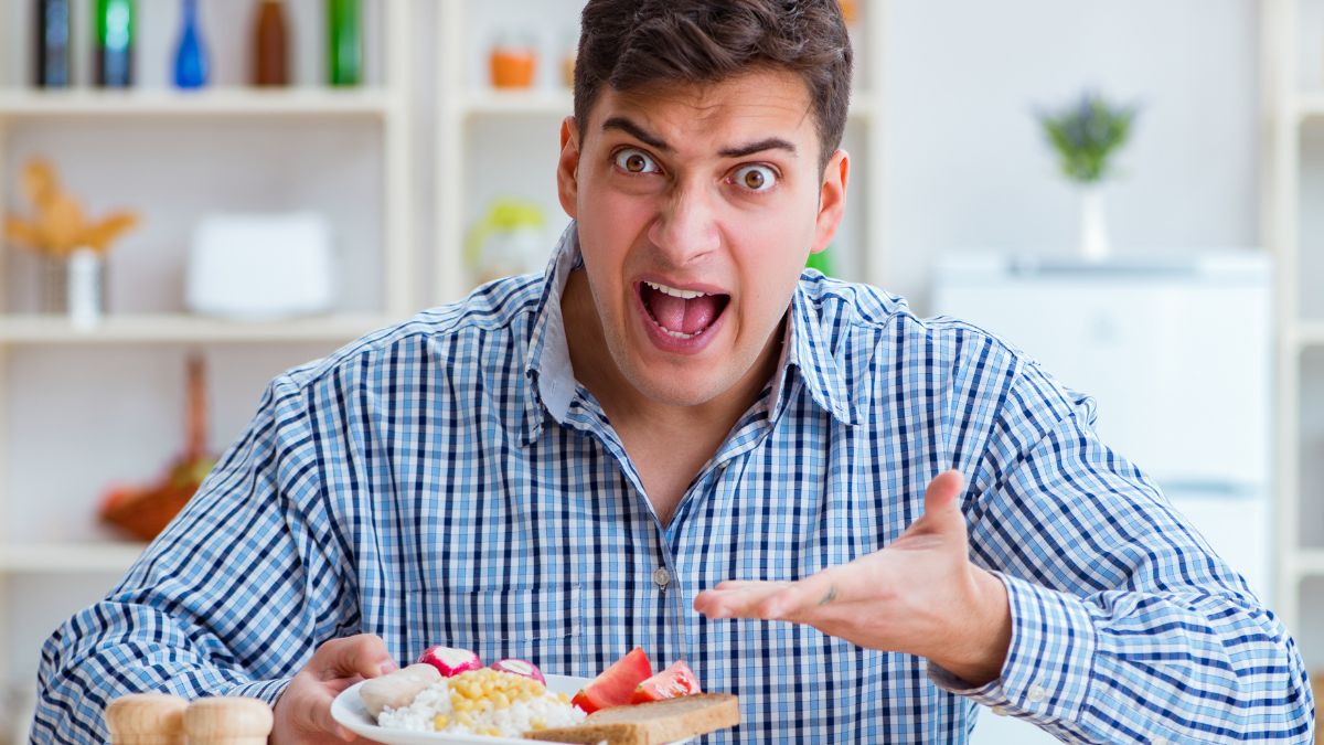 man looking confused with plate of food