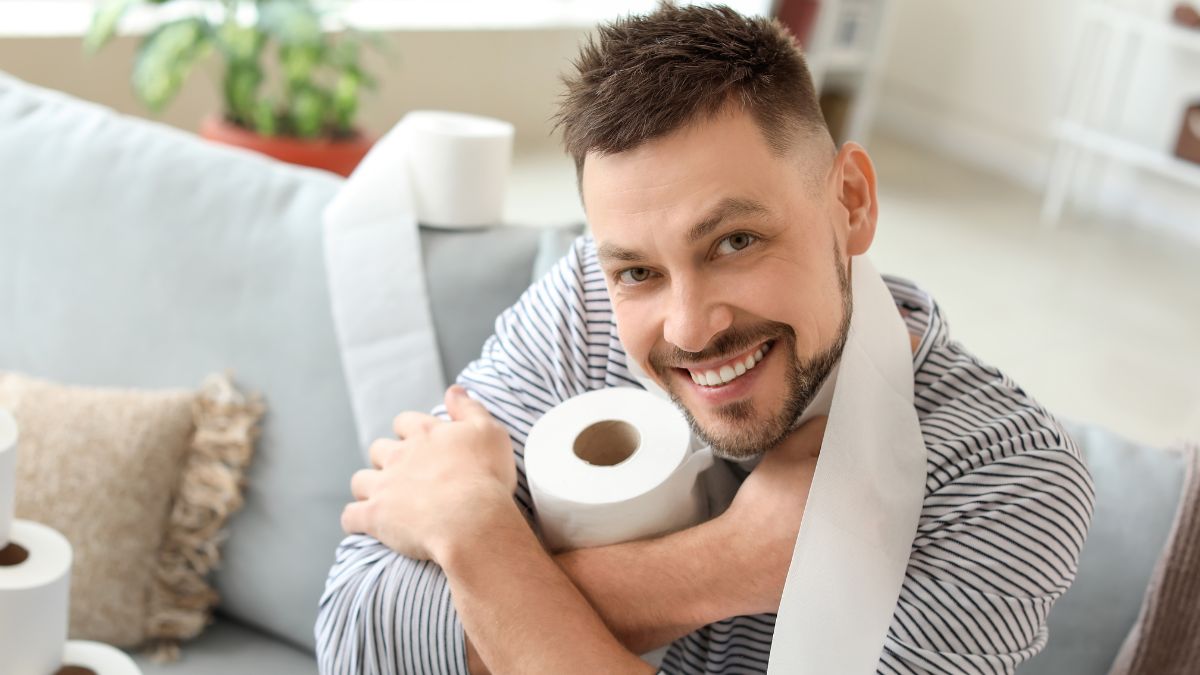 man smiling with toilet paper