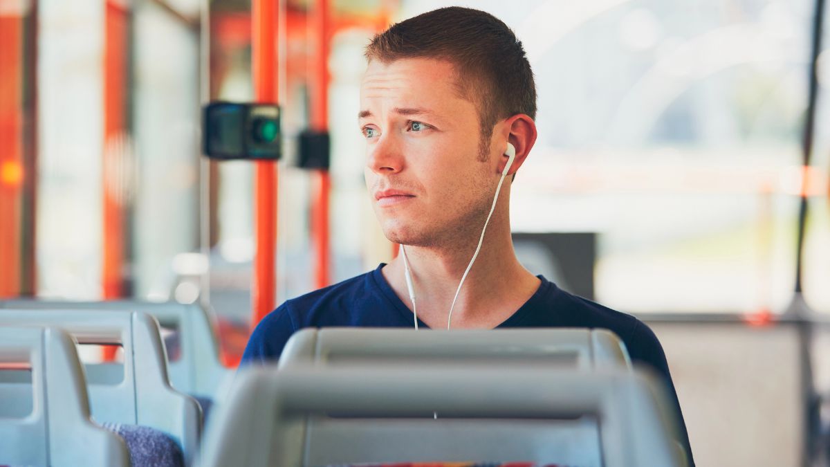 man traveling by bus with headphones