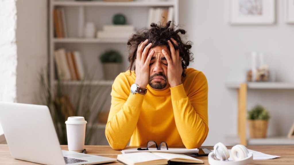 man with computer looking stressed