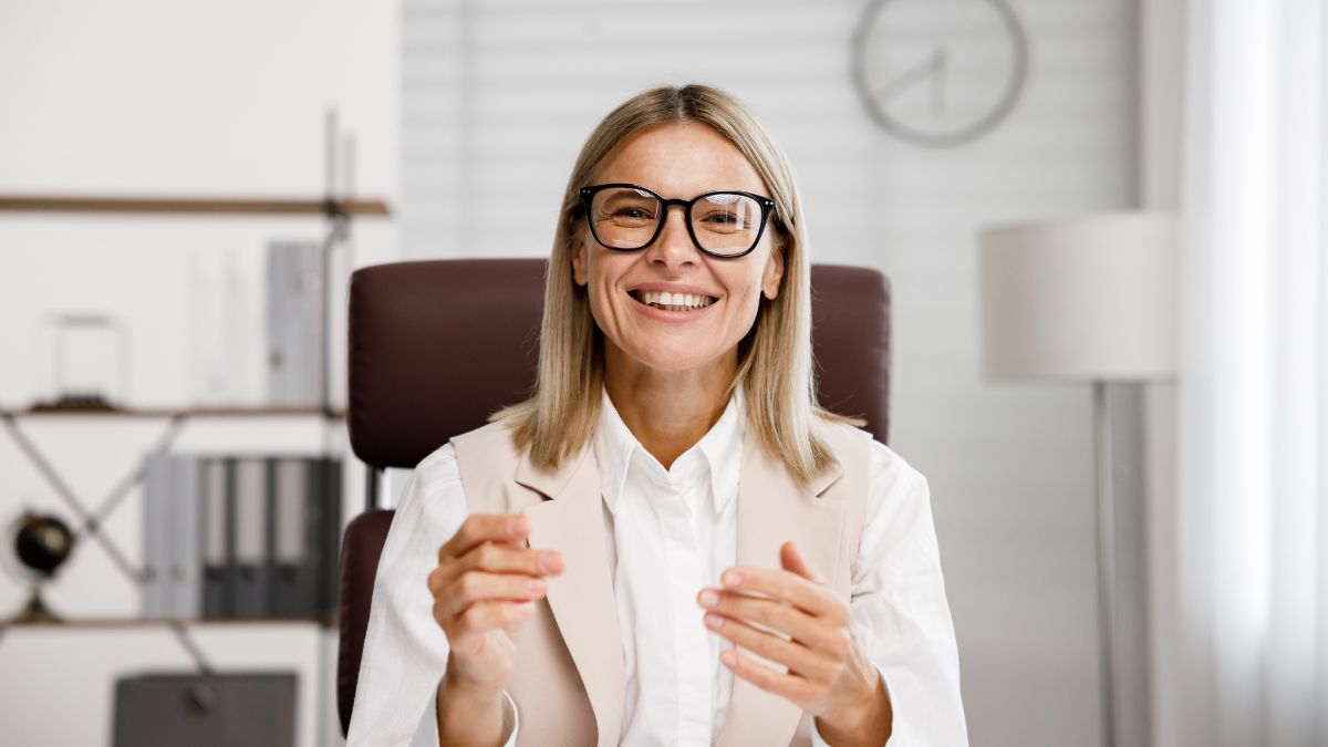 middle aged woman smiling at her desk