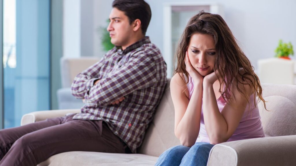 upset couple looking away from each other on the couch