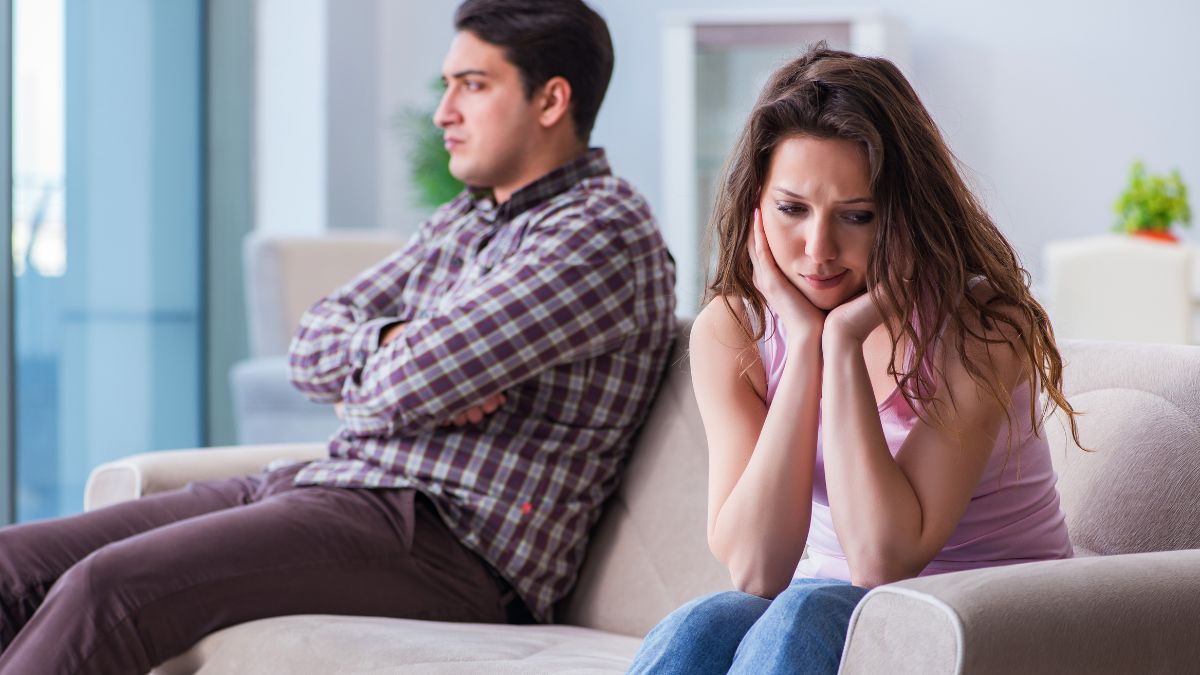 upset couple looking away from each other on the couch