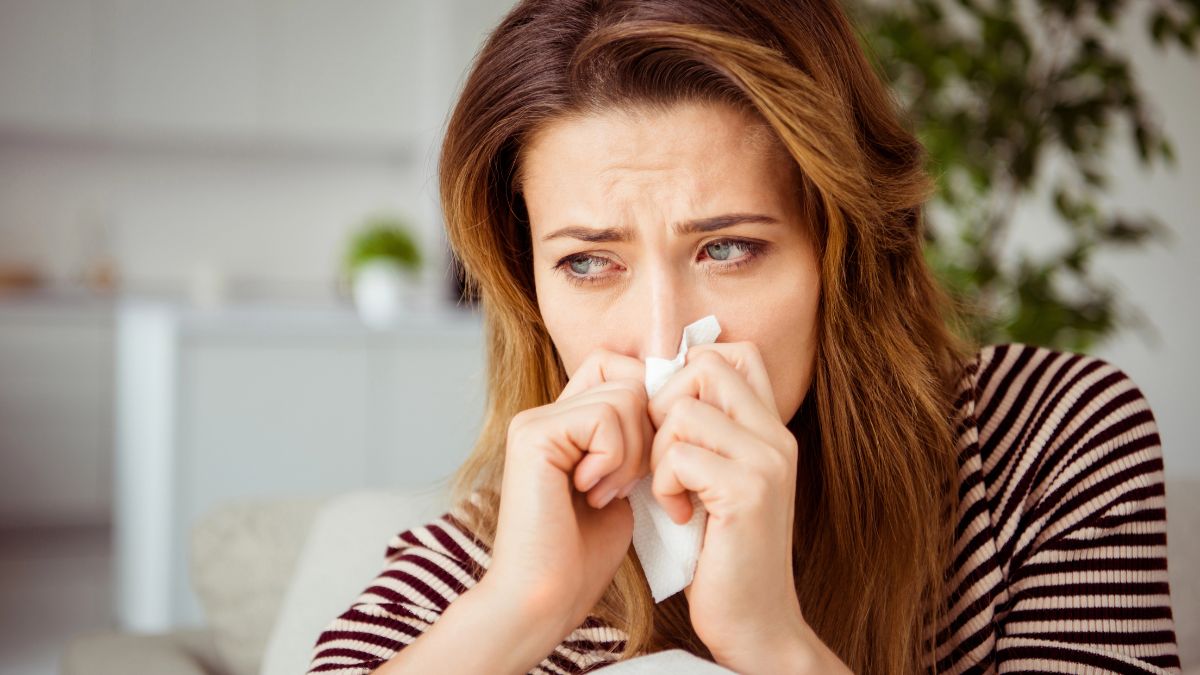 woman crying with tissue covering mouth