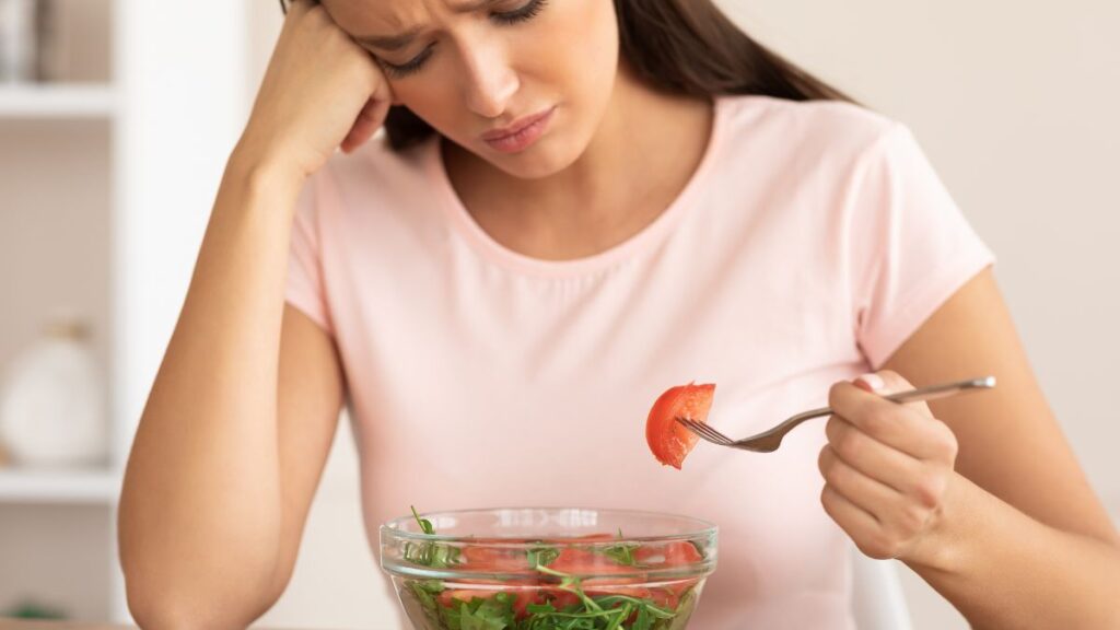 woman eating a salad depressed