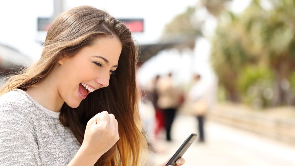 woman excited looking at phone