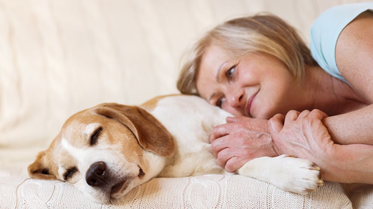 woman laying with sleeping dog