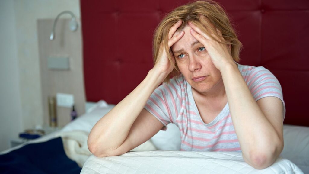 woman looking sad in bed