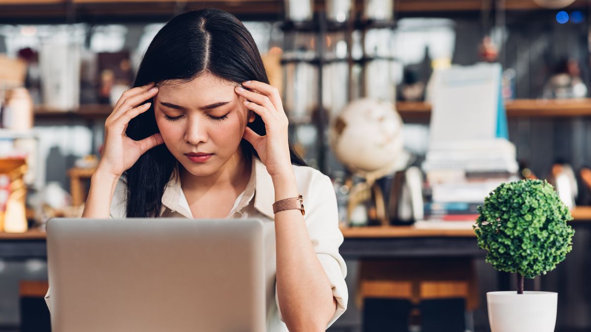 woman looking stressed at computer with hands on head