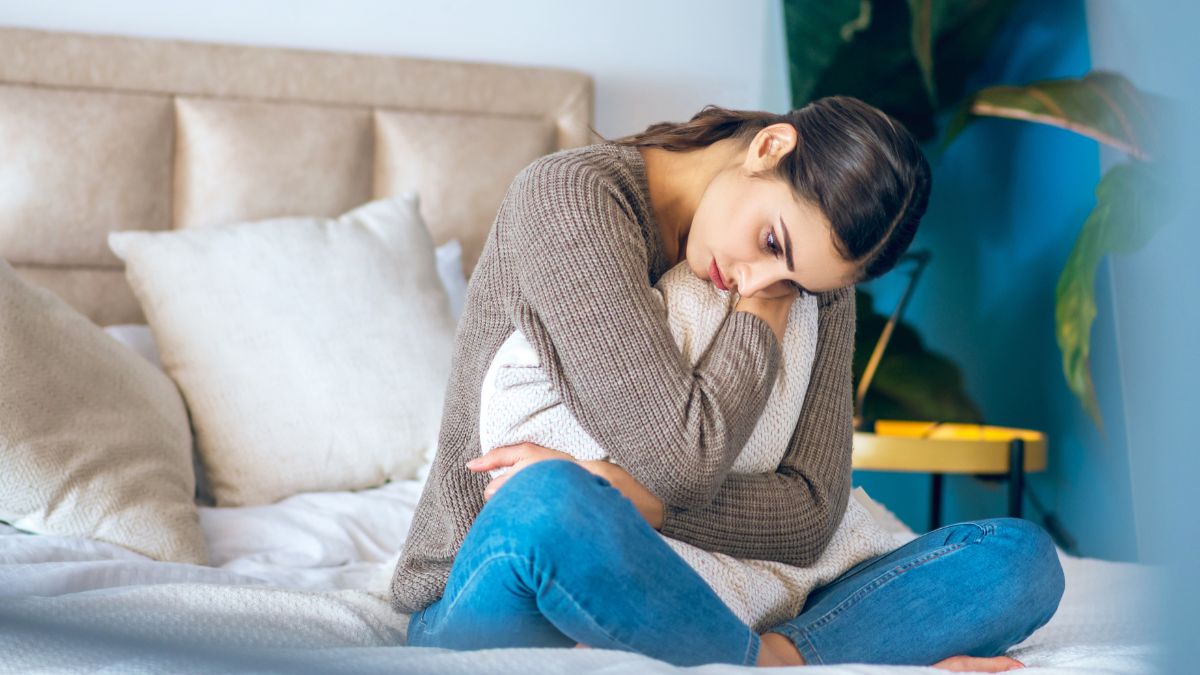 woman looking upset sitting on the bed