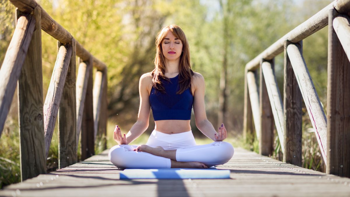 woman meditating on a bridge