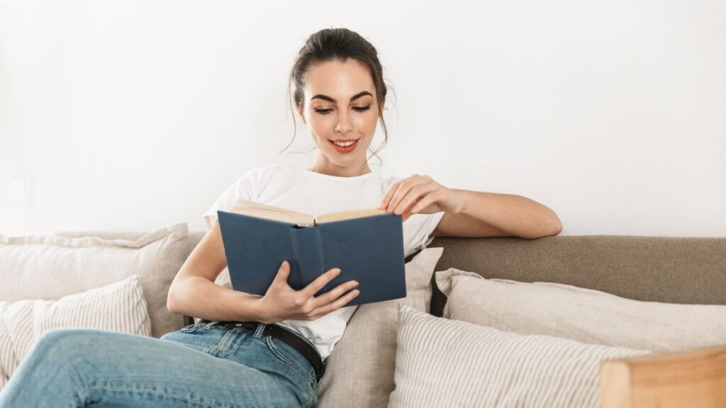 woman reading a book on the couch