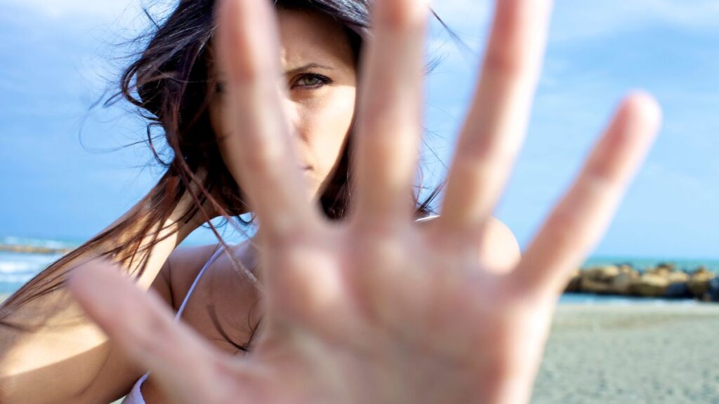 woman with her hand up close to the camera as to say stop