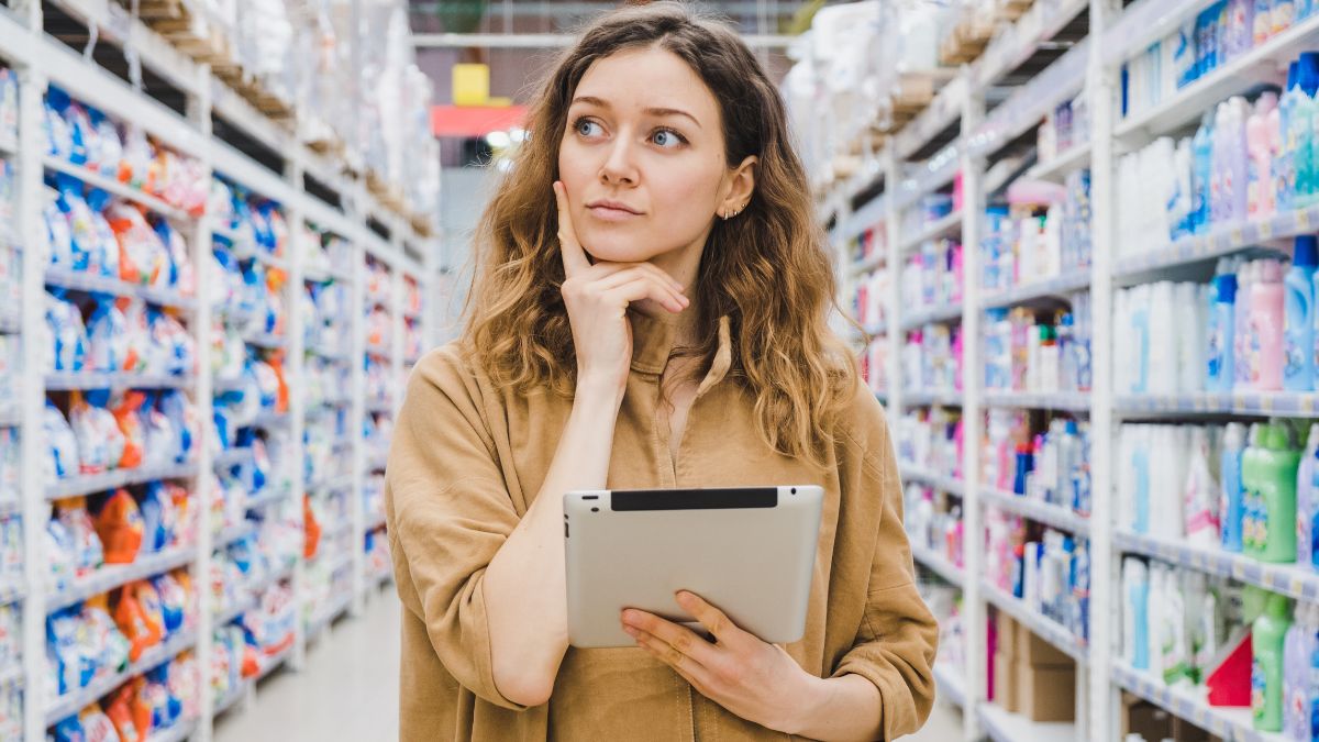 woman with ipad in store thinking about shopping