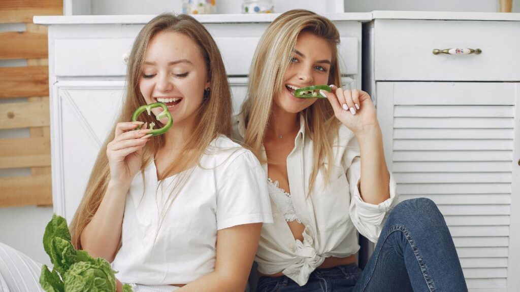 Girls eating peppers on the floor