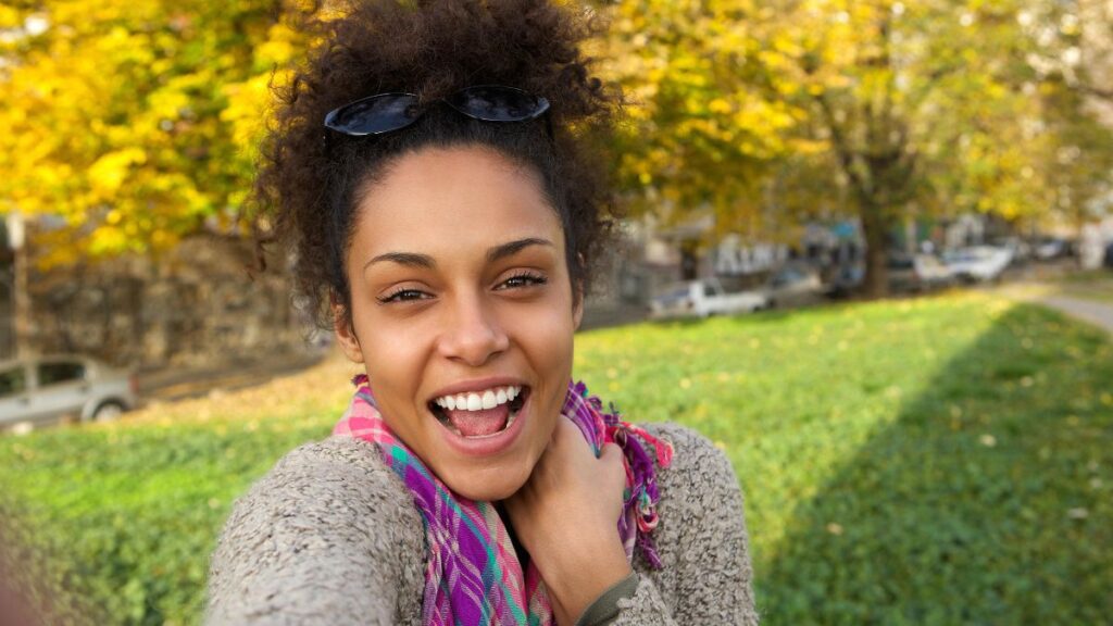 Happy woman smiling in a selfie outside