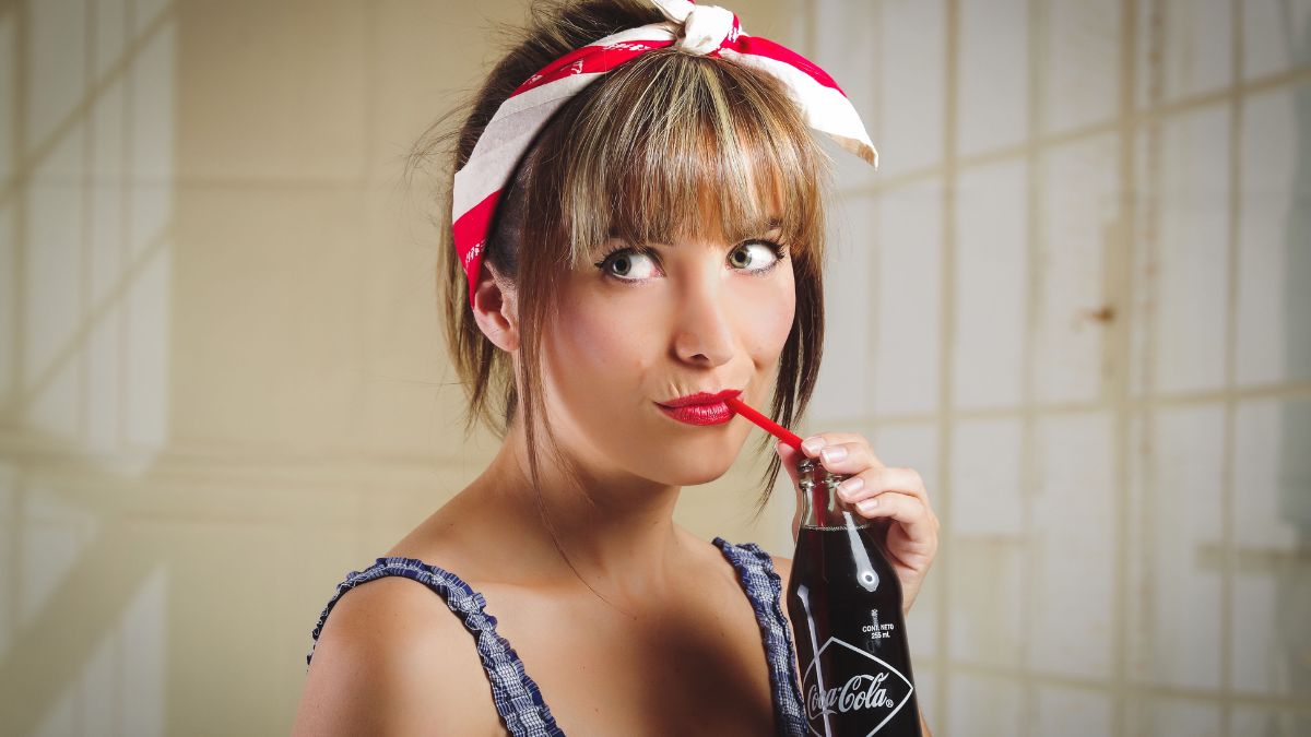 Woman with a head scarf and sipping coke -