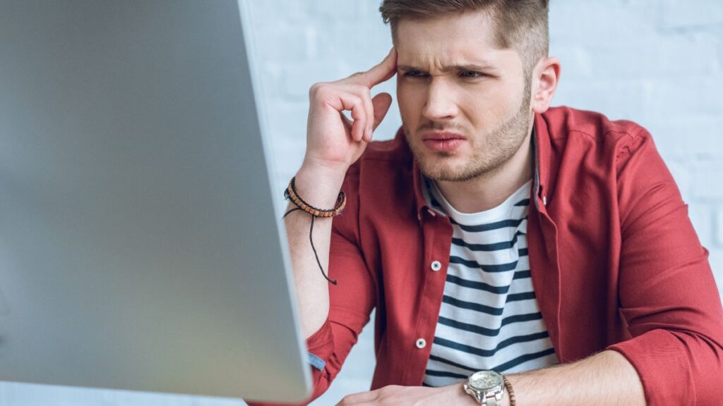 confused man looking at computer