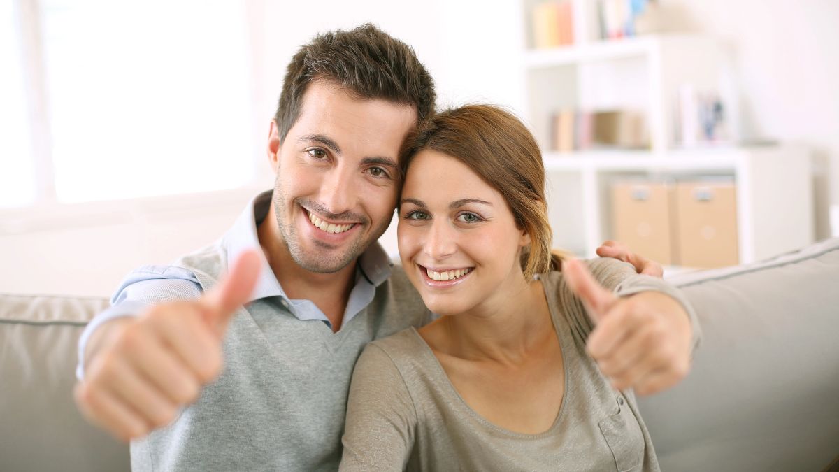 couple giving thumbs up on the couch