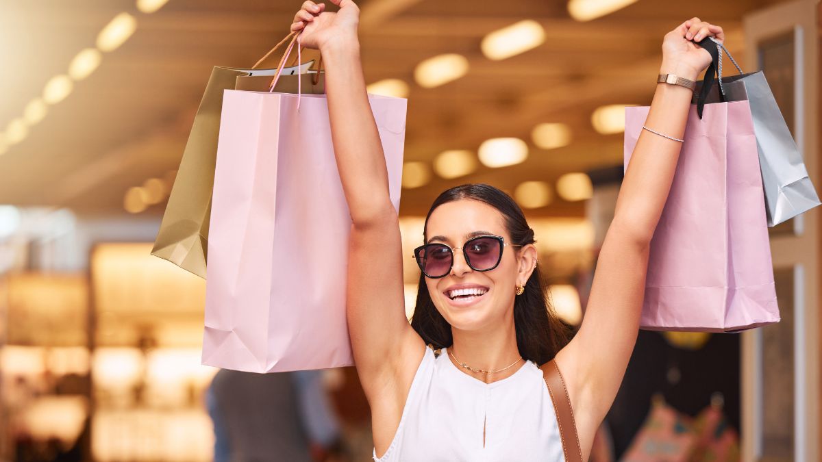 excited woman holding up shopping bags smiling