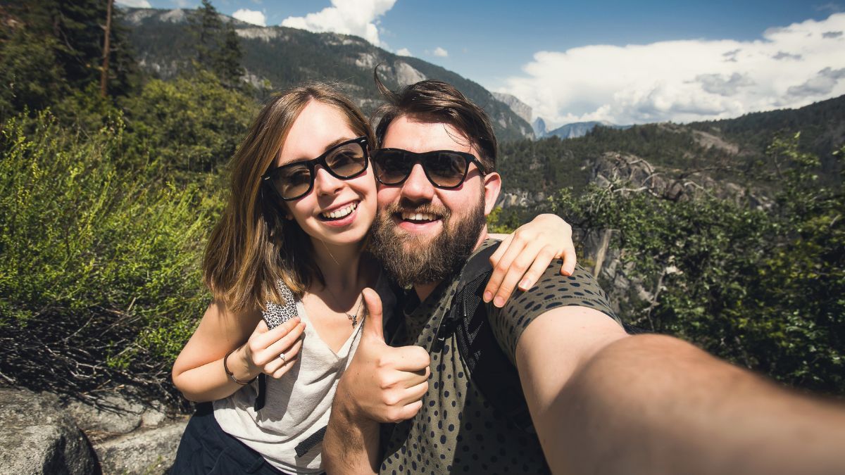 happy couple traveling and showing thumbs up