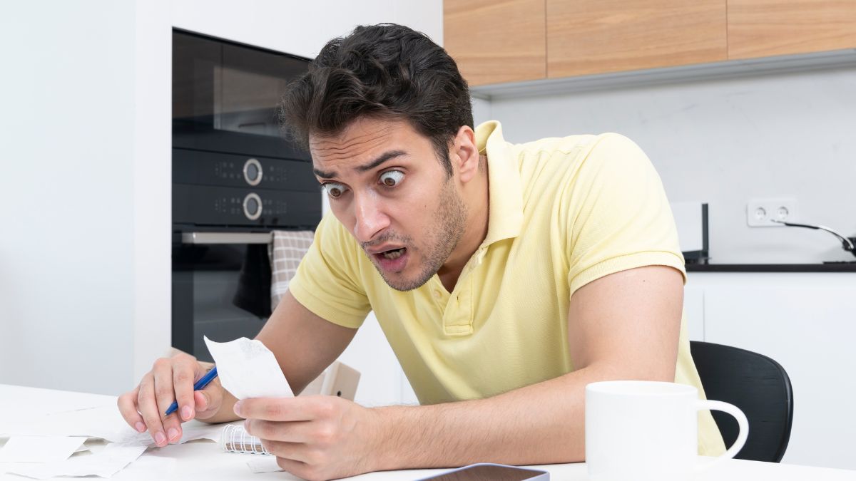 man looking stressed with receipt