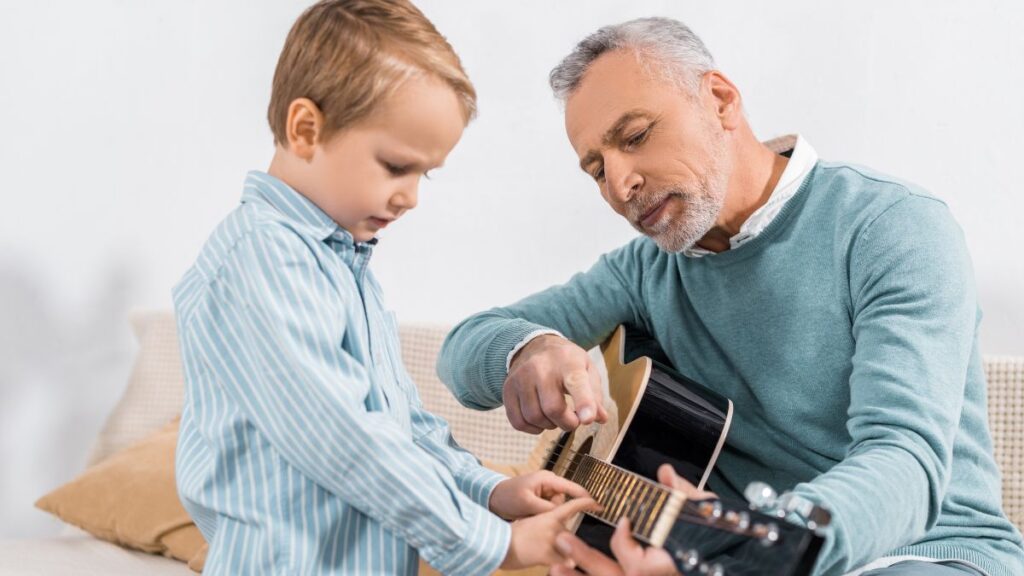 man looking teaching a child guitar