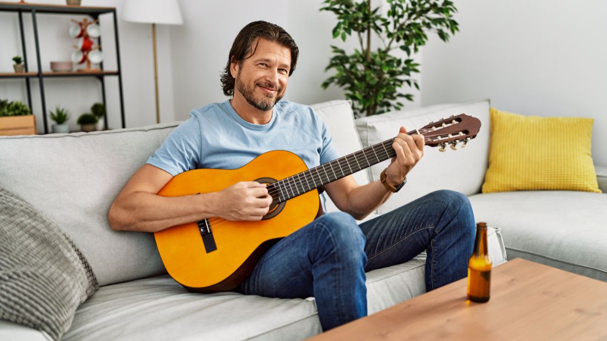 man on couch playing guitar