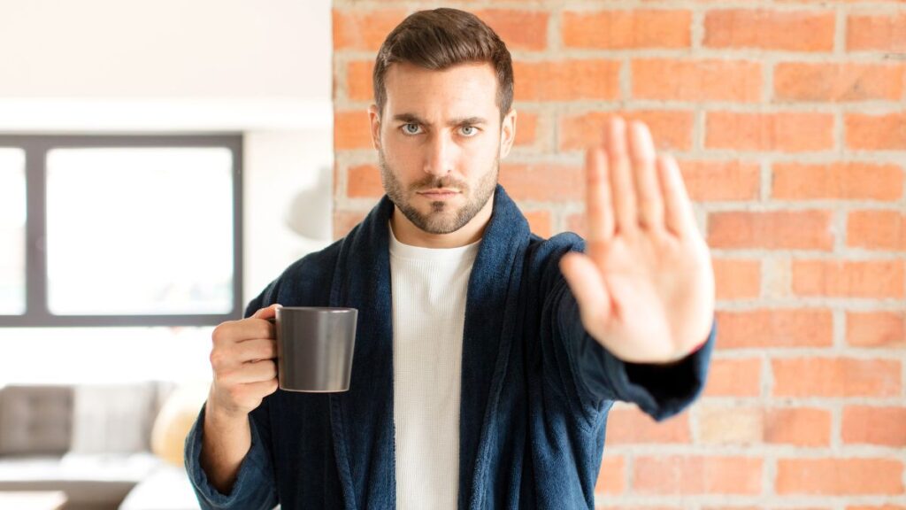 man with coffee showing stop