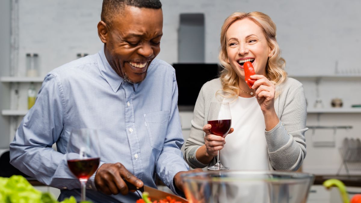 middle aged couple happy and cooking