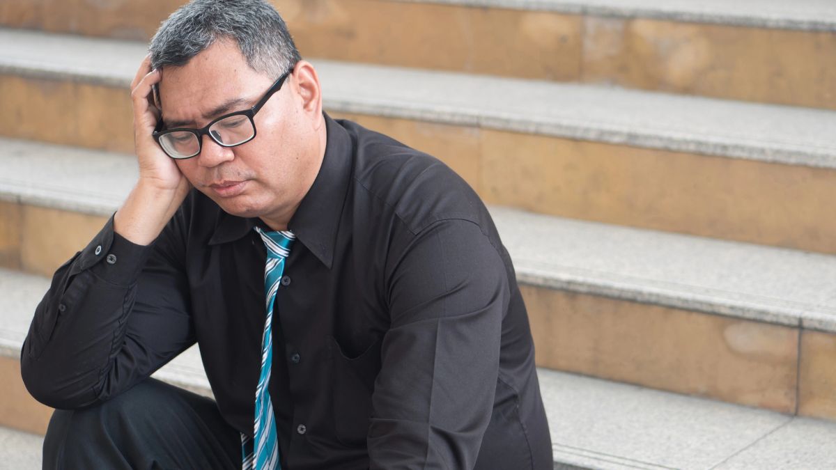 upset older man sitting on steps