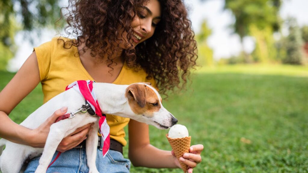 woman feeding dog ice cream