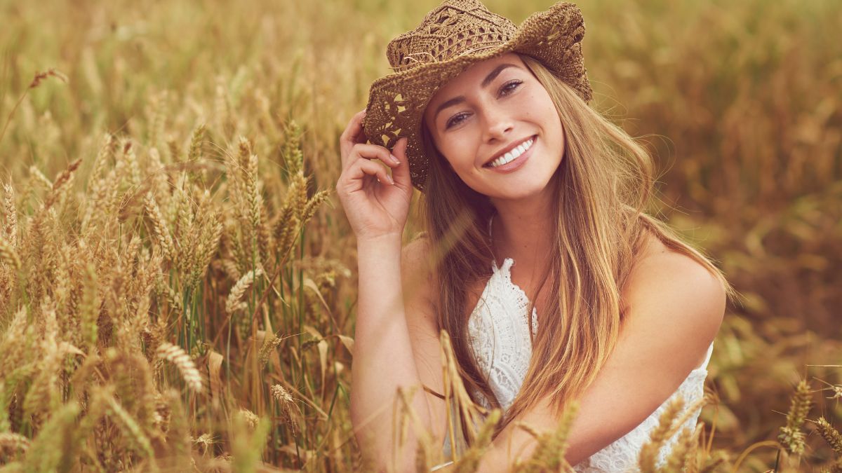 woman in cowboy hat sitting in the field