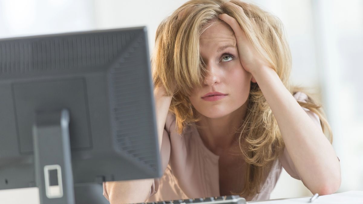 woman looking frustrated at the computer hands on head