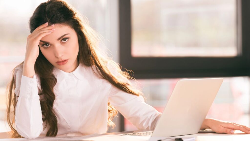 woman looking stressed and tired at computer