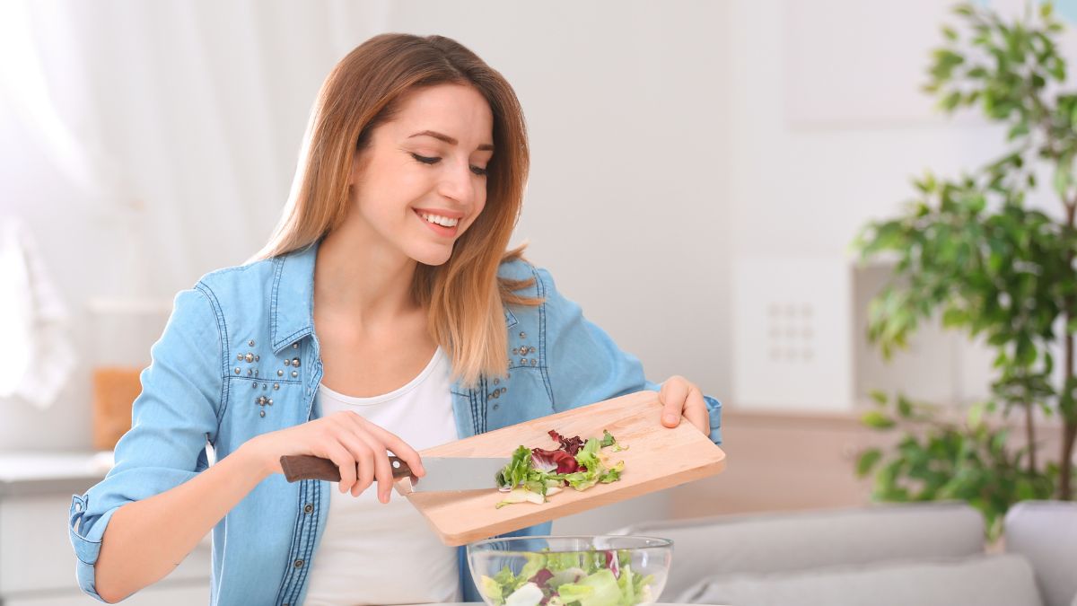 woman making a salad smiling