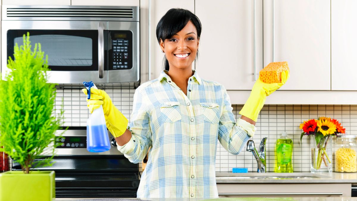 woman smiling in kitchen cleaning