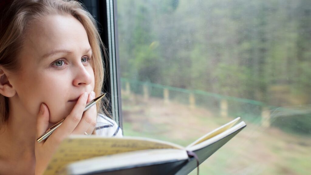 woman with a book and pen on the train