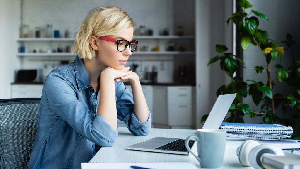 woman working at computer hands under chin